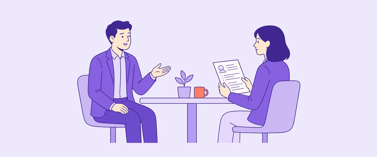 A candidate answering an interview question while the interviewer listens, holding a CV